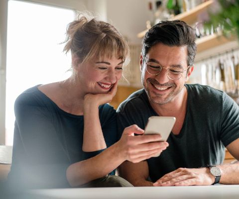 Un homme et une femme organisent le quotidien de leur famille sur un smartphone 