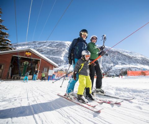 Eltern und Kind nehmen den Skilift zusammen