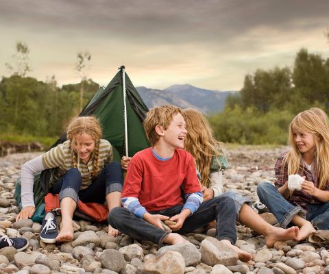 I bambini siedono insieme di fronte a una tenda piantata