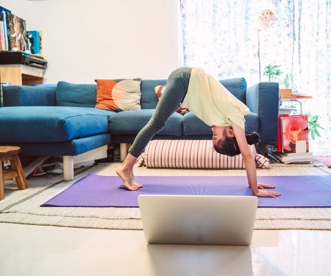 Mädchen macht Yoga in Wohnzimmer
