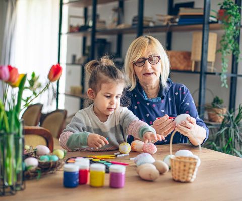 Nonna e nipote colorano insieme le uova di Pasqua