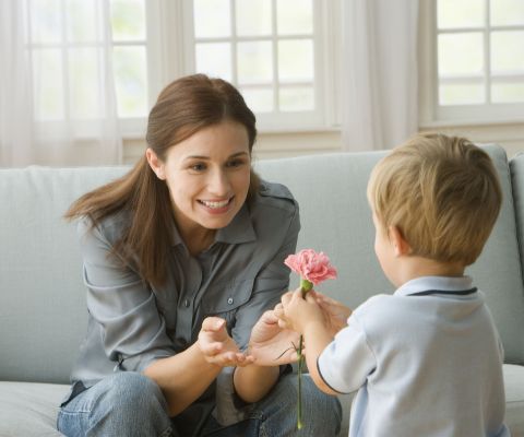Un bimbo regala un fiore alla mamma