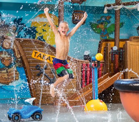 Jeune garçon en costume de bain en train de sauter joyeusement en l’air