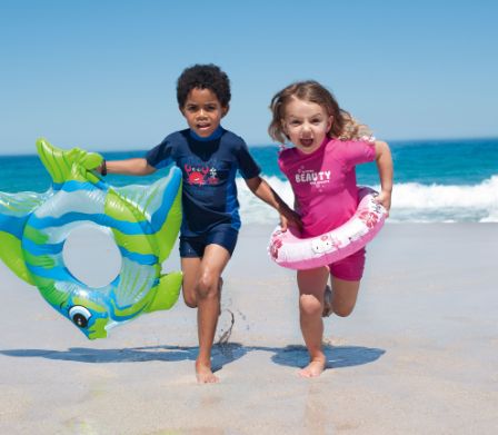 Deux enfants avec des bouées courant sur la plage