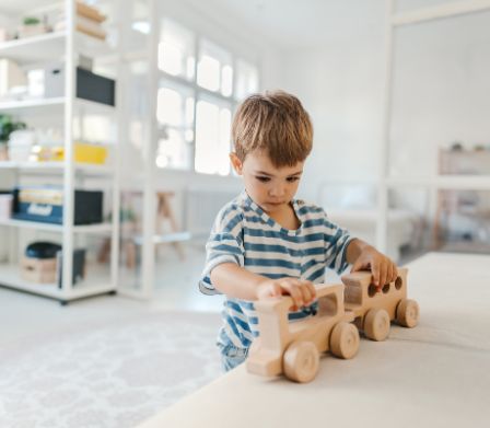 Kleiner Junge spielt mit nachhaltigem Holzspielzeug