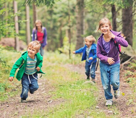 Quattro bambini corrono nel bosco