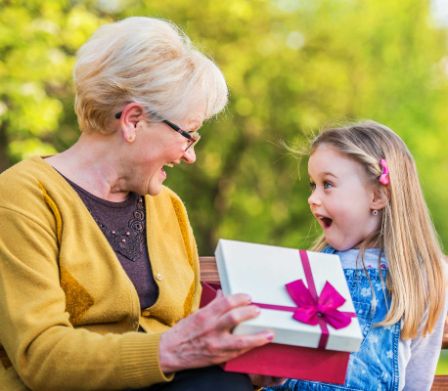 Grossmutter schenkt Mädchen ein Geschenk zum Schulanfang