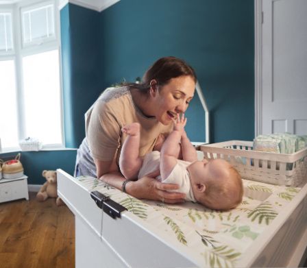 Eine Mutter wickelt ihr Baby auf dem Wickeltisch