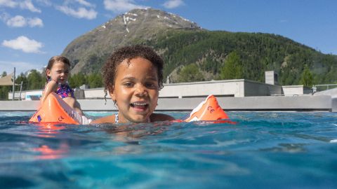 Un enfant portant des brassards de natation se baigne dans le bassin extérieur du parc aquatique Bellavita.