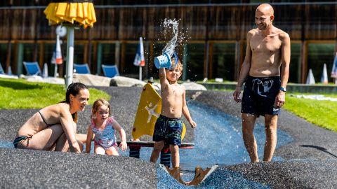 Familie badet in den Aussenanlagen des Erlebnisbads "eau-là-là"