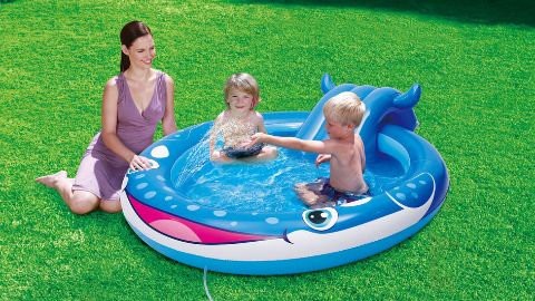 Madre e due bambini in una piscinetta con un piccolo scivolo