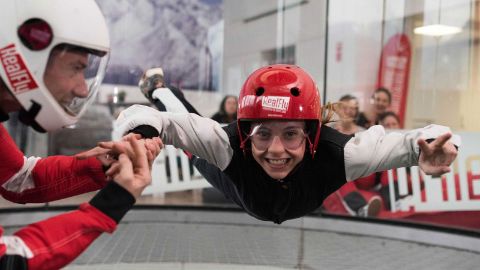 Ein Kind fliegt mit Hilfe einer Aufsichtsperson im Freifallsimulator RealFly in Sion.