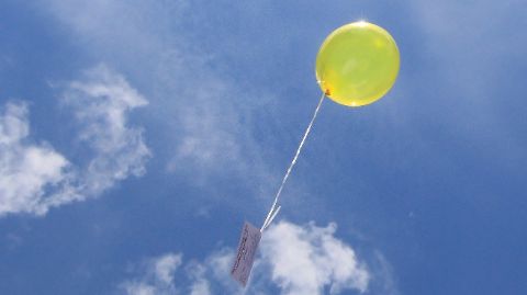 Ballon jaune avec une carte montant dans le ciel bleu Ballon jaune avec une carte montant dans le ciel bleu