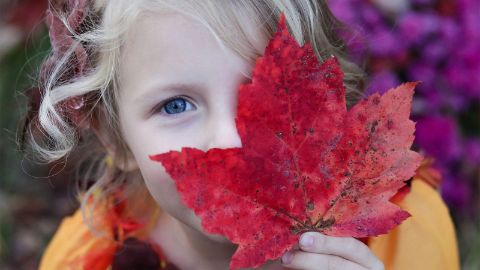 Bambina con foglia autunnale