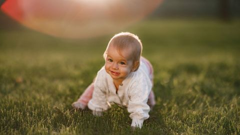 Un bébé rampe dans l’herbe