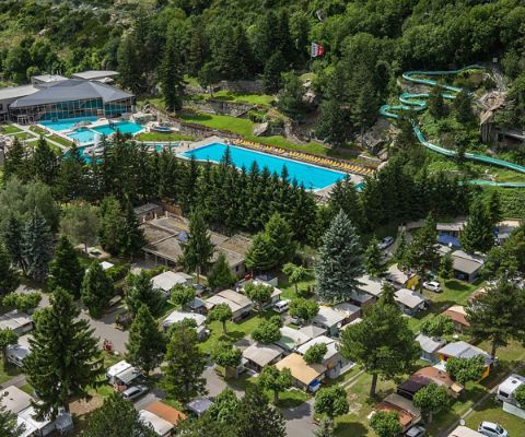 Vue plongeante sur le camping de Brigerbad, équipé de plusieurs piscines et toboggans aquatiques