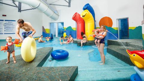 Père et fille dans la piscine extérieure du Swiss Holiday Park Resort de Morschach