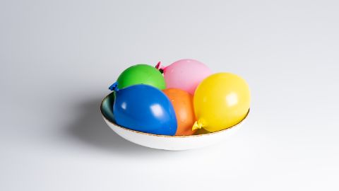 Les ballons de baudruche remplis d’eau sont déposés dans un saladier.