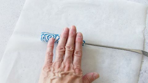 Le fette di FIMO vengono premute sul manico della forchetta da fondue
