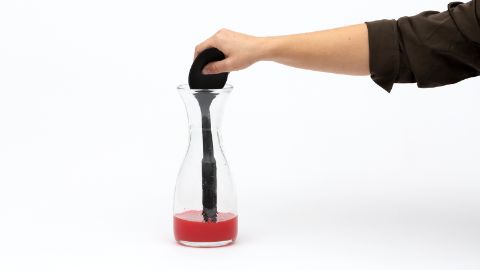 Mescolare bene l'acqua colorata nella bottiglia con il manico sottile di un mestolo.