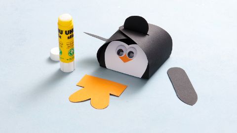 La scatola a forma di pinguino viene piegata e assemblata