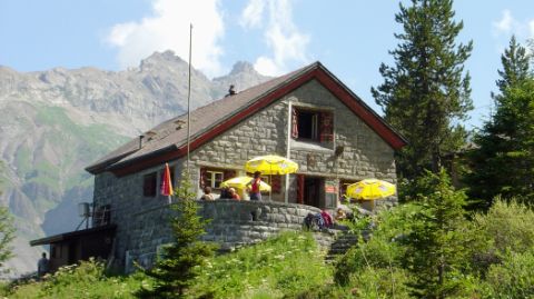 Contre-plongée d’une cabane avec des hôtes sur une terrasse ensoleillée
