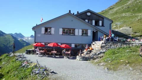 Gäste auf einer Terrasse einer SAC Berghütte