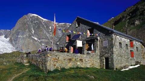 SAC Hütte vor Bergen und strahlend blauem Himmel