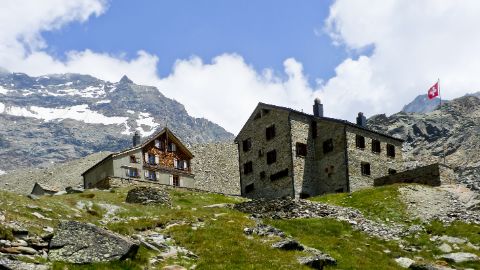 Zwei SAC Hütten nebeneinander vor karstiger Bergkulisse