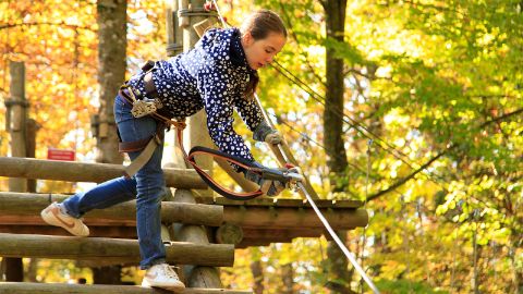 Mädchen klettert gesichert im Parc Aventure Chaumont Mädchen klettert gesichert im Parc Aventure Chaumont
