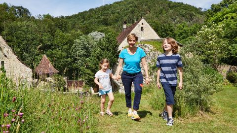 Mutter mit zwei Kindern und im Hintergrund Burg Birseck in Baselland