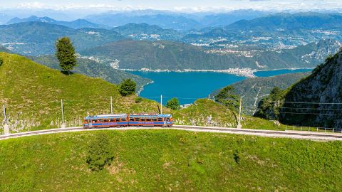 Die Zahnradbahn auf den Monte Generoso vor Alpen-Panorama und dem Luganersee