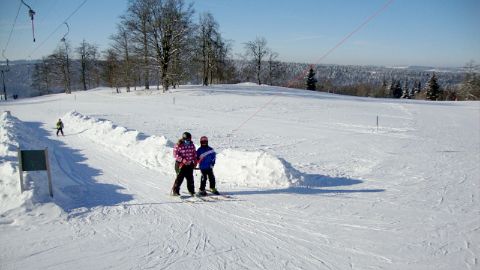 Ansicht des verschneiten Skigebietes Paquier bei Cret du Puy mit Schlepplift