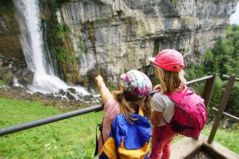 Zwei Kinder schauen sich den Wasserfall in Quinten an