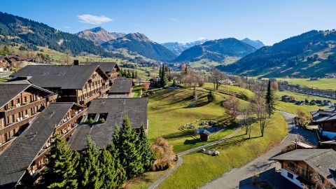 HUUS Hotel Gstaad mit Wiese und Aussicht auf Berge HUUS Hotel Gstaad mit Wiese und Aussicht auf Berge