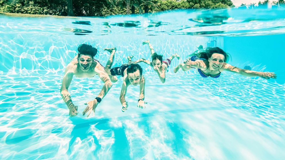 Familie taucht im Pool