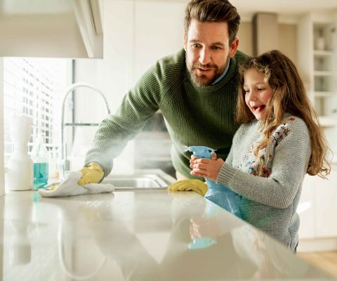 Vater und Tochter entfernen den hartnäckigen Kalk in der Küche