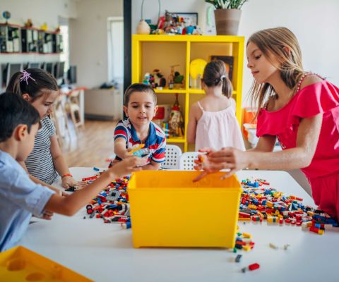 Kinder räumen LEGO Steine auf