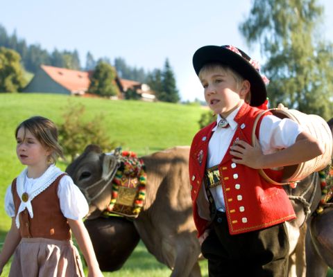 Bambina e bambino in abiti tradizionali con mucche