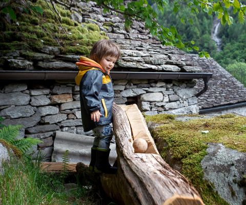 Junge bestaunt die «Boccia al Bosco»: Kugelbahn auf der Wanderung im Verzascatal