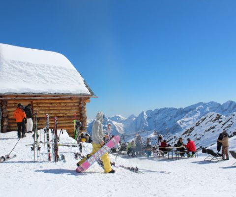 Snowboarder vor Skihütte in Bosco Gurin