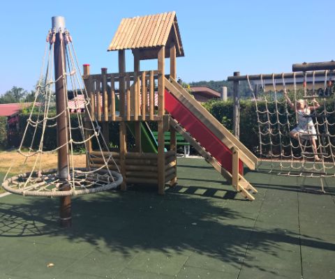 Parco giochi per bambini con scivolo e torre per arrampicarsi