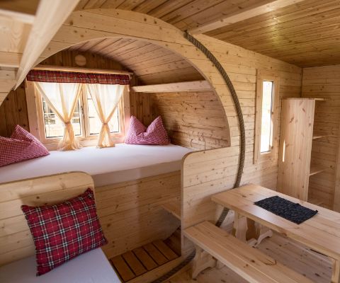 Gemütliche Fasshütte mit Bettkoje und Esstisch auf dem Camping Sutz am Bielersee