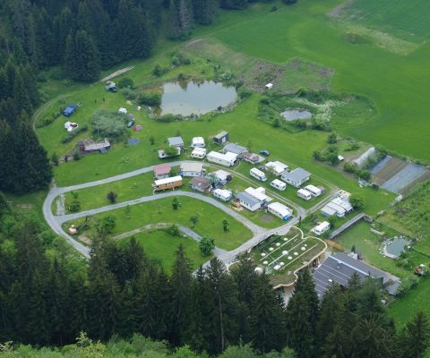 Campingplatz Trin von oben mit Weiher, Bungalows und Wohnwagen