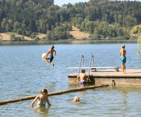 Des enfants sautent d’un radeau dans le lac