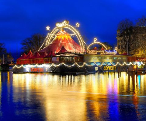 Beleuchteter Weihnachtszirkus reflektiert im Wasser