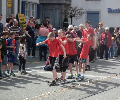 Enfants en route avec des planches tandem lors de la course aux œufs de Sissach