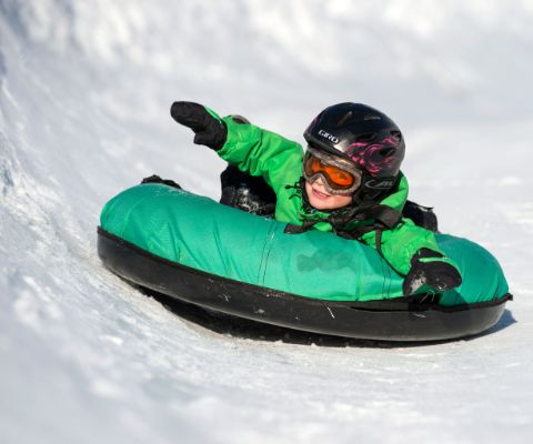 Un petit garçon en pleine action sur la piste de snowtubing 