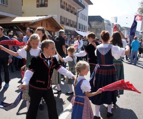 Bambini e adulti in costume tradizionale festeggiano per strada