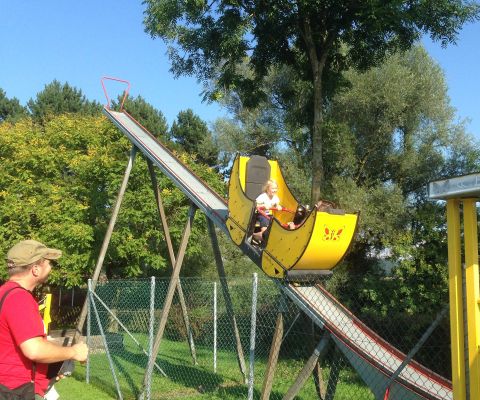 Bambini seduti in una “banana” al parco divertimenti di Sitterdorf